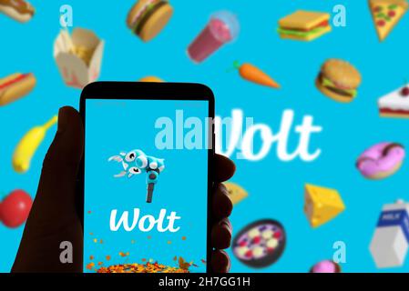 Il logo Wolt dell'app per la consegna di alimenti è visto sullo schermo di un telefono cellulare e sul display di un computer portatile a Barcellona, in Spagna, il 16 novembre 2021 Foto Stock