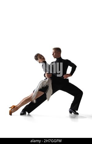 Ritratto dinamico di giovani ballerini aggraziati, uomo flessibile e donna danza sala da ballo isolato su sfondo bianco studio. Foto Stock