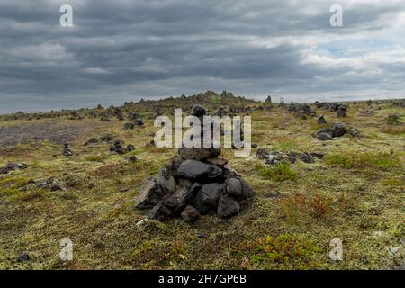 Vista ravvicinata ad angolo basso di un cumulo di cairn o di pietra al crinale lavico di Laufskalavarda in Islanda, costruito dai viaggiatori che attraversano il deserto di Myrdalssandur Foto Stock