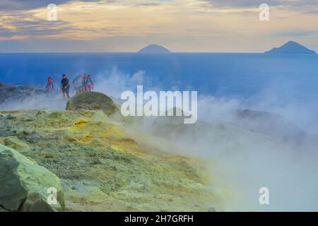 Gli escursionisti che camminano attraverso fumarole fumano sul bordo del Gran Cratere, Isola di Vulcano, Isole Eolie, Sicilia, Italia, Foto Stock