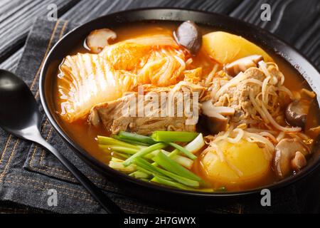 Gamja-tang o stufato di backbone di maiale è una zuppa coreana piccante da vicino nella ciotola sul tavolo. Orizzontale Foto Stock
