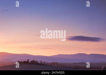 Paesaggio toscano con cipressi e cascina di sunrise, San Quirico d'Orcia, Val d'Orcia, Toscana, Italia Foto Stock