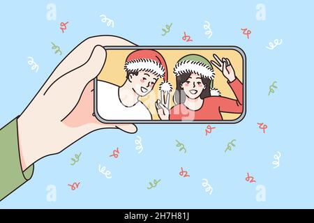 Concetto di festa di Capodanno online. Smartphone con mano umana in mano con sorridente coppia di cappelli Babbo Natale festeggiamento e saluto on-line illustrazione vettoriale Illustrazione Vettoriale