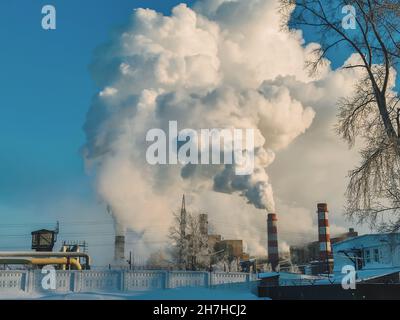 Emissioni di camino dalle centrali elettriche industriali di lignite. Enormi nubi di fumo da camini, tubi di una centrale termica, inquinando l'atmosfera Foto Stock