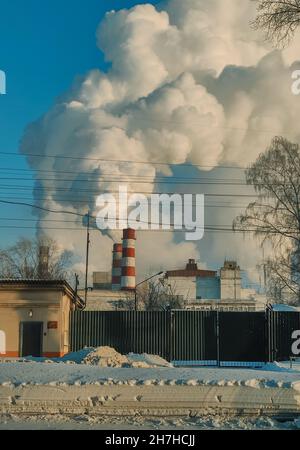 Enormi nubi di fumo da camini, tubi di una centrale termica, inquinando l'atmosfera inquinamento atmosferico da camini di centrale. Foto Stock