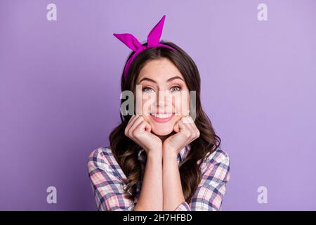 Ritratto fotografico di adorabile ragazza che tiene faccia con due mani isolate su vivido sfondo viola colorato Foto Stock