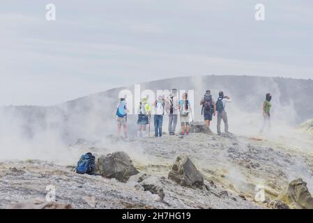 Gli escursionisti che camminano attraverso fumarole fumano sul bordo del Gran Cratere, Isola di Vulcano, Isole Eolie, Sicilia, Italia, Foto Stock