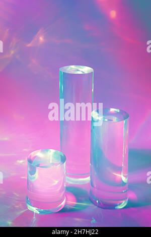 tre podi in vetro chiaro su sfondo rosa pastello Foto Stock
