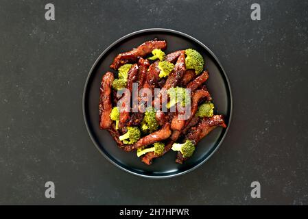 Manzo e broccoli mescolare friggere su sfondo scuro. Vista dall'alto, piatto Foto Stock