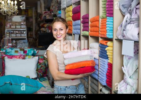 donna cliente che raccoglie asciugamani da bagno. Foto Stock