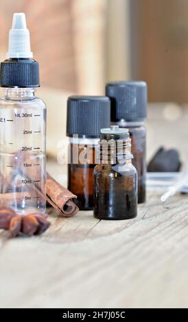 bottiglie di olio essenziale con spezie, bastone di cannella e stella di anice Foto Stock