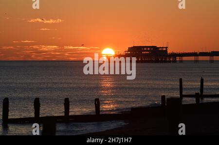 Worthing UK 23 novembre - il sole tramonta dietro Worthing Pier dopo una giornata soleggiata ma fredda lungo la costa meridionale : Credit Simon Dack / Alamy Live News Foto Stock