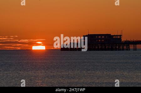 Worthing UK 23 novembre - il sole tramonta dietro Worthing Pier dopo una giornata soleggiata ma fredda lungo la costa meridionale : Credit Simon Dack / Alamy Live News Foto Stock