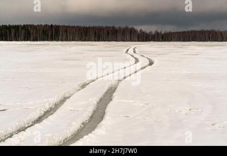 Ruote tortuose su un lago ghiacciato. Giorno d'inverno. Regione di Leningrad. Foto Stock