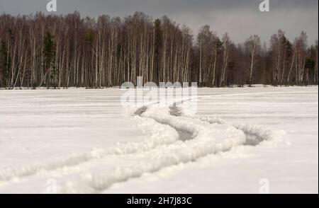 Ruote tortuose su un lago ghiacciato. Giorno d'inverno. Regione di Leningrad. Foto Stock