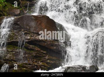 Cascata che si rompe su vecchie pietre Foto Stock