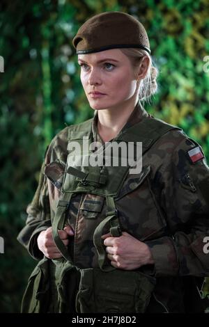 Ritratto di una giovane donna soldato in piena attrezzatura e uniforme militare. Foto Stock