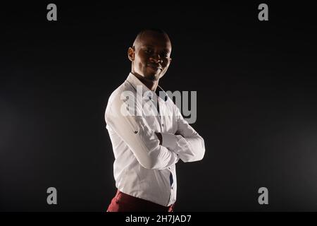 Il maschio nero adatto sta posando in stuio su sfondo scuro Foto Stock