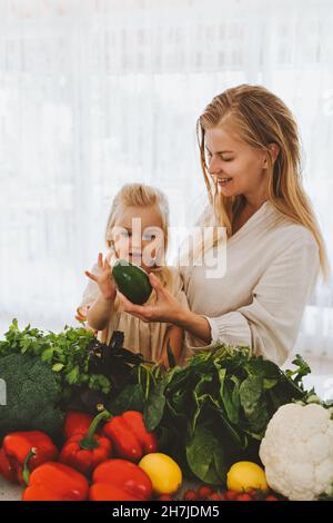 Famiglia madre e bambino ragazza che cucinano cibo vegano insieme ortaggi biologici mangiare sano stile di vita sostenibile agricoltura biologica raccolto drogheria shopping Foto Stock