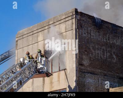 Oak Park, Illinois, Stati Uniti. 23rd novembre 2021. I vigili del fuoco combattono un incendio in più su Lake Street, nel quartiere commerciale del centro di questo sobborgo vicino a Chciago. Si pensa che il fuoco sia iniziato nella cucina di Delia's Kitchen, un popolare locale da pranzo, ma questo non è certo. Foto Stock