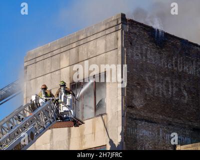 Oak Park, Illinois, Stati Uniti. 23rd novembre 2021. I vigili del fuoco combattono un incendio in più su Lake Street, nel quartiere commerciale del centro di questo sobborgo vicino a Chciago. Si pensa che il fuoco sia iniziato nella cucina di Delia's Kitchen, un popolare locale da pranzo, ma questo non è certo. Foto Stock