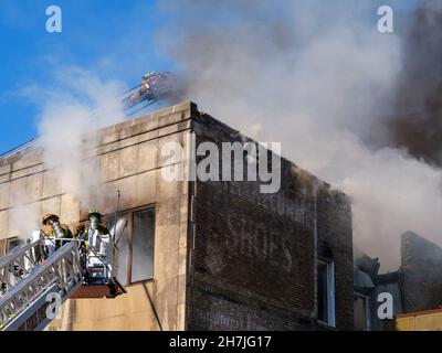 Oak Park, Illinois, Stati Uniti. 23rd novembre 2021. I vigili del fuoco combattono un incendio in più su Lake Street, nel quartiere commerciale del centro di questo sobborgo vicino a Chciago. Si pensa che il fuoco sia iniziato nella cucina di Delia's Kitchen, un popolare locale da pranzo, ma questo non è certo. Foto Stock