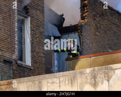 Oak Park, Illinois, Stati Uniti. 23rd novembre 2021. I vigili del fuoco combattono un incendio in più su Lake Street, nel quartiere commerciale del centro di questo sobborgo vicino a Chciago. Si pensa che il fuoco sia iniziato nella cucina di Delia's Kitchen, un popolare locale da pranzo, ma questo non è certo. Foto Stock