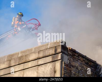 Oak Park, Illinois, Stati Uniti. 23rd novembre 2021. I vigili del fuoco combattono un incendio in più su Lake Street, nel quartiere commerciale del centro di questo sobborgo vicino a Chciago. Si pensa che il fuoco sia iniziato nella cucina di Delia's Kitchen, un popolare locale da pranzo, ma questo non è certo. Foto Stock