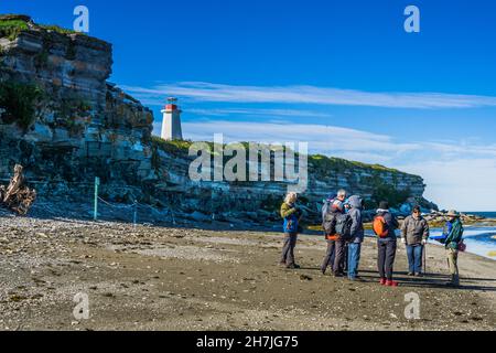 Dipendente del Canada Parks che fornisce spiegazioni ai visitatori sulla nidificazione di pulcinelle su Ile aux Perroquets, uno degli arcipelago Mingan nella regione della Cote Nord Foto Stock