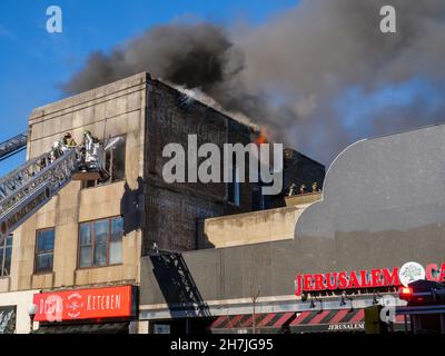 Oak Park, Illinois, Stati Uniti. 23rd novembre 2021. I vigili del fuoco combattono un incendio in più su Lake Street, nel quartiere commerciale del centro di questo sobborgo vicino a Chciago. Si pensa che il fuoco sia iniziato nella cucina di Delia's Kitchen, un popolare locale da pranzo, ma questo non è certo. Foto Stock