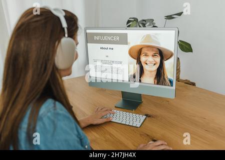 Influencer femminile utilizzando il computer e navigare nel blog Foto Stock