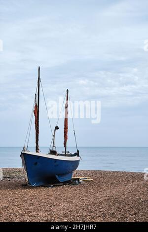 Una tradizionale barca da pesca si trova sulla spiaggia di pietra di Rock A Nore che si affaccia sul canale della Manica, Hastings, East Sussex, Regno Unito. Foto Stock