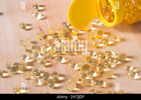 Pillole di omega di olio di pesce versate da una bottiglia Foto Stock