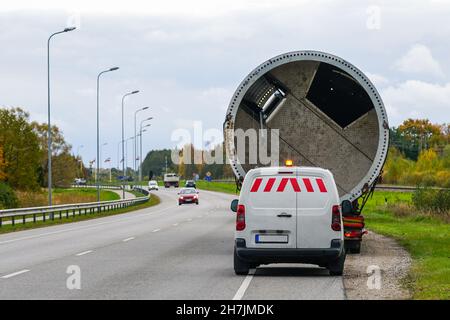 trasporto di merci voluminose su strada con un rimorchio pesante e un'auto di accompagnamento Foto Stock