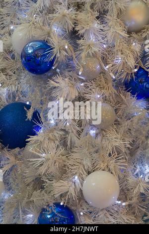 Ornamenti di Natale appesi su un albero artificiale Foto Stock