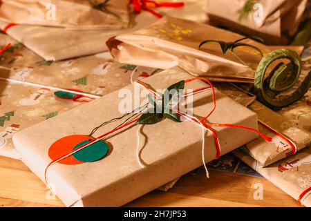Regali di Natale Composition.Xmas con i nastri verdi rossi ed il decor.presenta del ramo dell'albero avvolto in carta riciclata artigianale e in vacanza di arco.Inverno della corda Foto Stock