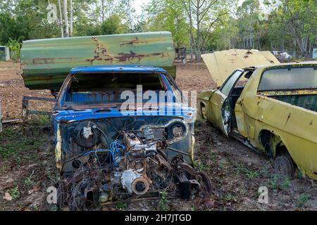 Le conchiglie arrugginite delle vecchie auto sono rimaste in un cortile rurale Foto Stock