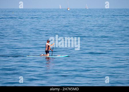 Paddleboarder su un mare calmo al largo di Megavissey, Cornovaglia, Regno Unito. Foto Stock