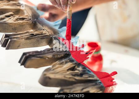 Mani di una donna con un pennello per dipingere lettere di polistirene Foto Stock