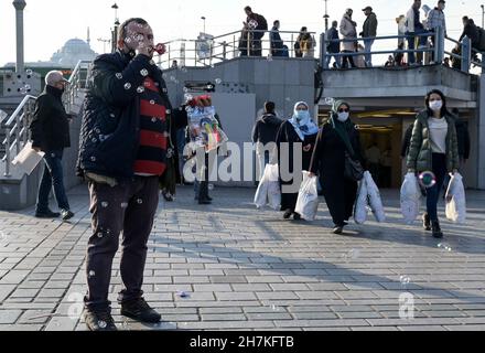 TURCHIA, Istanbul, Eminönü stazione dei traghetti, corona pandemic, persone con maschere facciali, sapone bubble venditore / Türkei, Istanbul, Stadtteil Eminönü Fähranleger, Corona Pandemie, Passanten mit Masken Foto Stock