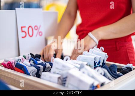 Closeup donna shopaholic mani scelta calze 50% di sconto alla boutique di moda Foto Stock