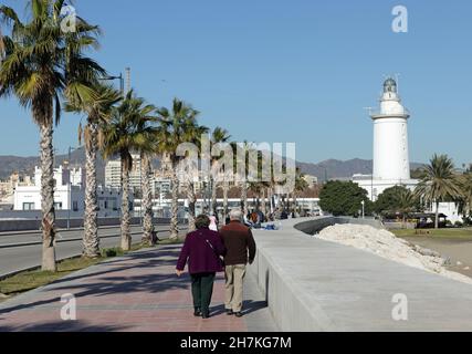 MALAGA, SPAGNA - 17 gennaio 2019: Malaga, Spagna, coppia anziana che cammina sul molo lungo la spiaggia di Malagueta verso il faro Foto Stock