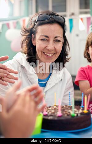 Donna sorridente che festeggia il compleanno con la famiglia Foto Stock