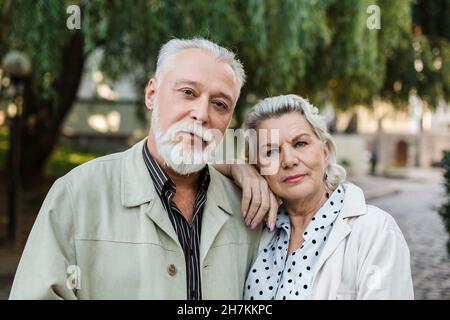 Donna anziana appoggiata sulla spalla dell'uomo Foto Stock
