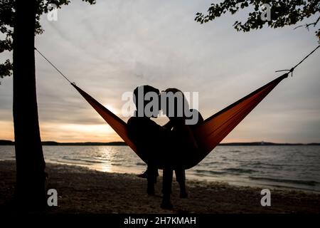 Coppia rilassante in amaca durante il tramonto Foto Stock