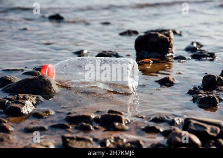 Bottiglia di plastica galleggiante sull'acqua Foto Stock