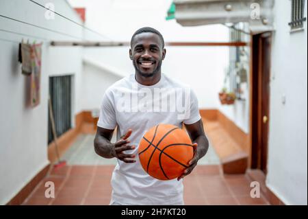 Sorridente giovane azienda basket Foto Stock