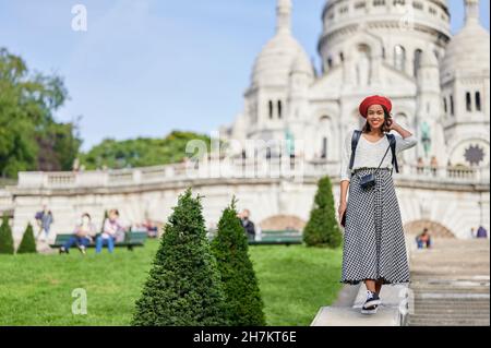 Turista femminile con mano in capelli a Basilique Du Sacre Coeur, Montmartre a Parigi, Francia Foto Stock