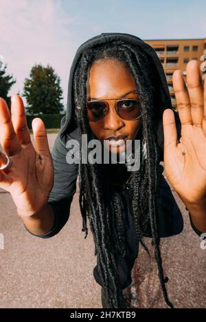 Donna con acconciature Locs gesturing a campo di pallacanestro Foto Stock