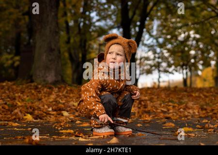 Toddler con bastone che gioca a poddle Foto Stock